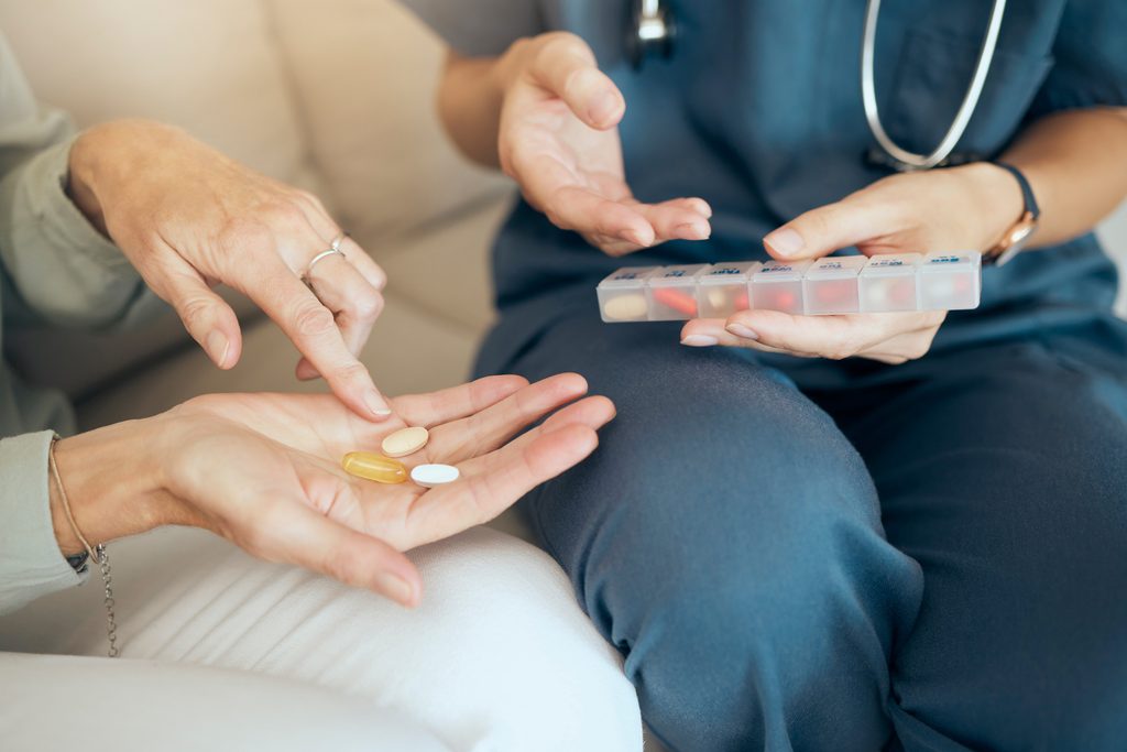 Nurse medication management: a nurse filling a pill box at home